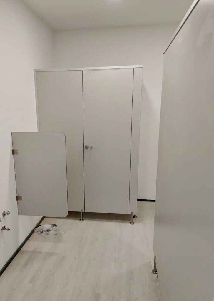 Vue d'ensemble d'un espace douche avec plusieurs cabines PMR installées