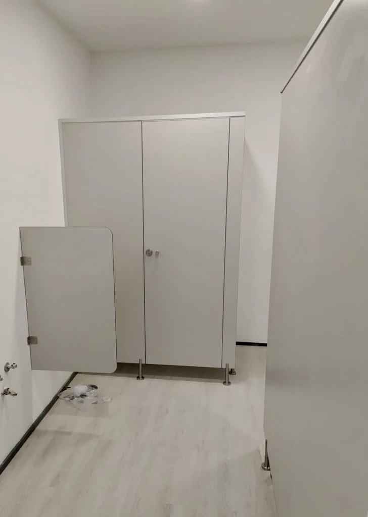Vue d'ensemble d'un espace douche avec plusieurs cabines PMR installées
