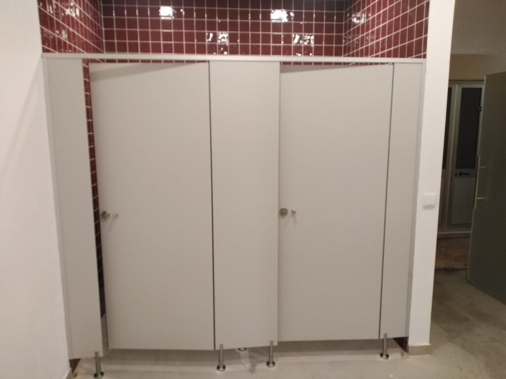 Séparateurs sanitaires professionnels avec fixations inox dans une cafétéria d'entreprise