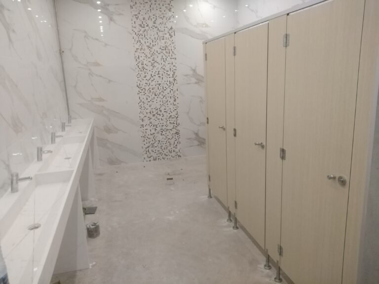 Aménagement des vestiaires humides pour une salle de sport avec des cabines stratifiées.