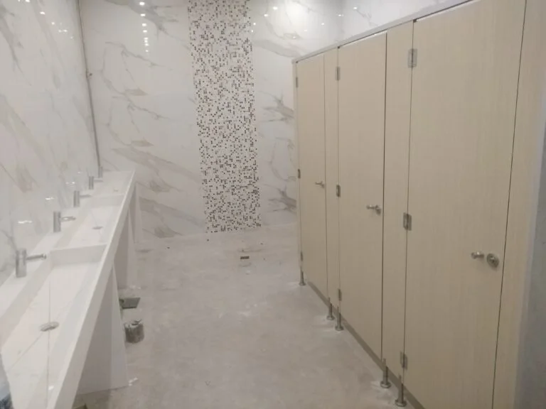 Aménagement des vestiaires humides pour une salle de sport avec des cabines stratifiées.