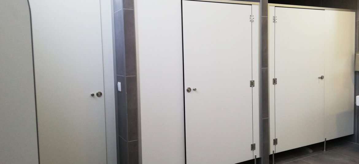 Aménagement d'un espace toilette avec des cabines sanitaires conçues spécialement pour ce lieu professionnel.