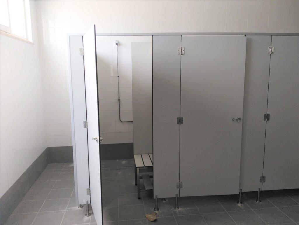 Installation de cabines sanitaires modernes dans un camping avec douches et toilettes séparées, conformes aux normes d'hygiène et d'accessibilité