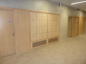 Casiers vestiaires multicases sur mesure en stratifié finition bois clair, installés en encastré dans un couloir collectif — Le Mobilier Stratifié