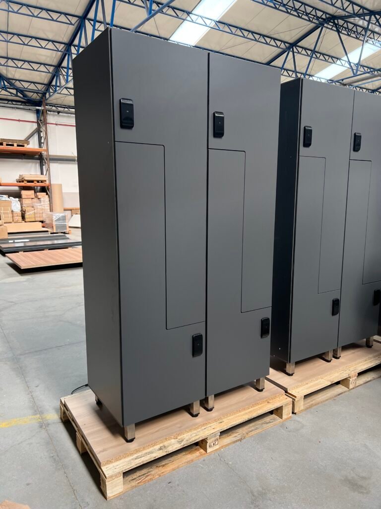 Batterie de casiers vestiaires en stratifié compact HPL coloris jaune vif, configuration 3 cases par colonne, équipés de serrures à code numérique Ojmar, installés dans un vestiaire carrelé gris foncé